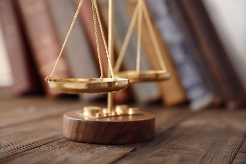Golden balance scales on wooden table