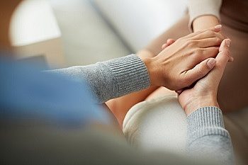 Close up of psychiatrist hands together holding palm of her patient