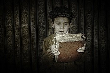 Child with red vintage book. Vintage clothes and hat