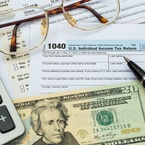 Tax form with pen, calculator, dollar banknote , and glasses taxation concept