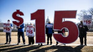 UNITED STATES   FEBRUARY 25: Activists with Our Revolution hold $15 minimum wage signs outside the Capitol complex on Thursday, Feb. 25, 2021, to call on Congress to pass the $15 federal minimum wage hike proposed as part of the COVID relief bill. (Photo By Bill Clark/CQ Roll Call, Inc via Getty Images)