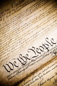 we the people   United States Constitution. Closeup, high contrast with light added grain.