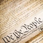 we the people   United States Constitution. Closeup, high contrast with light added grain.