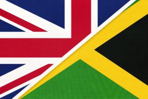 United Kingdom of Great Britain and Ireland vs Jamaica national flag from textile. Relationship, partnership and economic between two european and american countries.