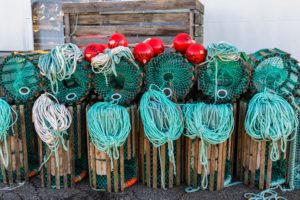 Lobster traps standing on a pier prepared for fishing with ropes and buoys in a Norwegian fishing village