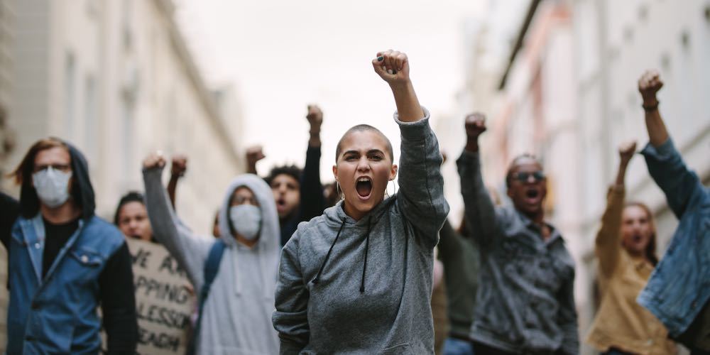 Group of people protesting and giving slogans in a rally. Group of demonstrators protesting in the city.