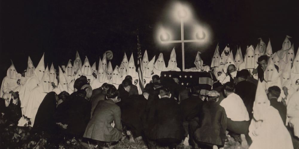 Ku Klux Klan gathered within two miles of the U.S. Capitol to receive new members, c. 1925 27. In the background are shrouded members, with the initiates kneeling in the foreground