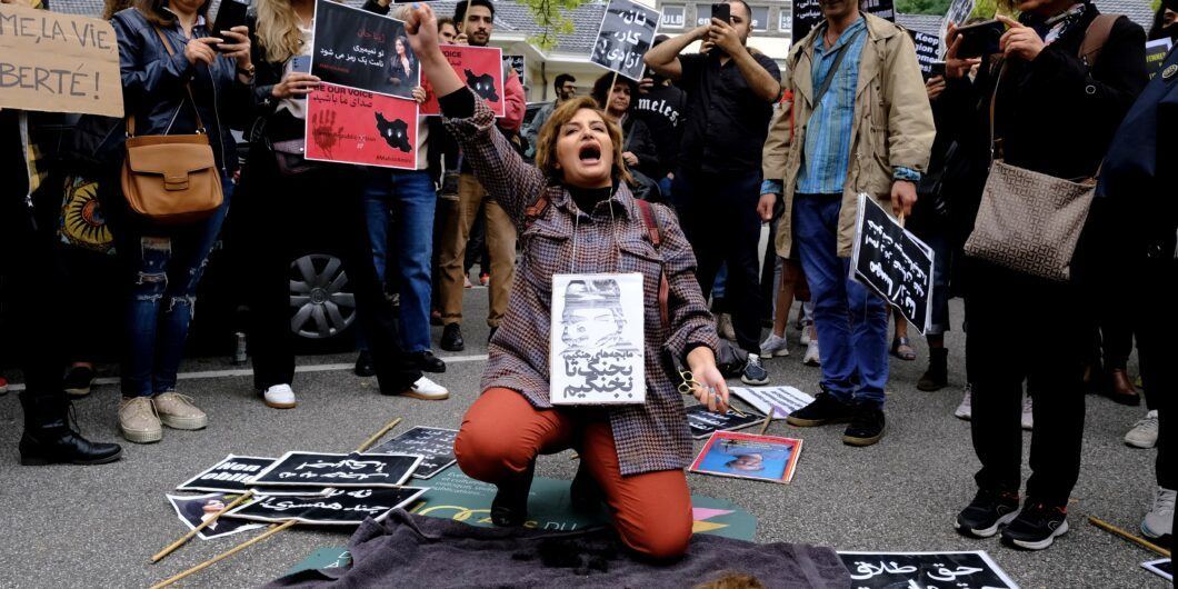 A woman cuts her hair during a demonstration in front of the Iranian embassy in Brussels, Belgium on Sept. 23, 2022, following the death of Mahsa Amini.