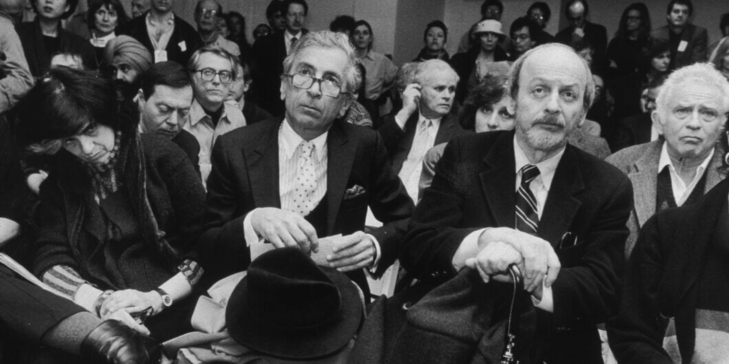 22nd February 1989:  From left to right, American authors Susan Sontag, Gay Talese, E L Doctorow and Norman Mailer seated among a group of people at Writers In Support of Salman Rushdie, New York CIty.  (Photo by Sara Krulwich/New York Times Co./Getty Images)